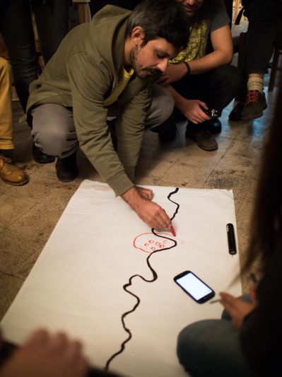 A man drawing on paper on the floor